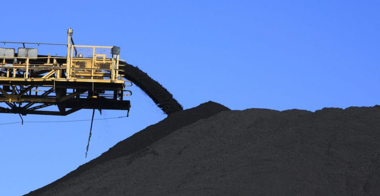 coal pouring from conveyor against blue sky (ukraine)