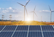 Australian renewable generation hits record high in grid Solar panels in front of wind turbines