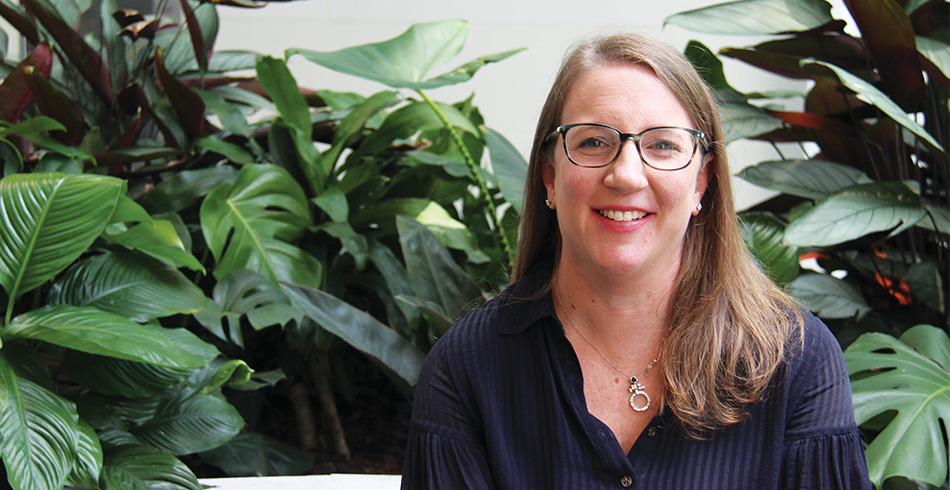 Emma-Roberts CS Energy's Emma Roberts poses smiling in front of lush green foliage