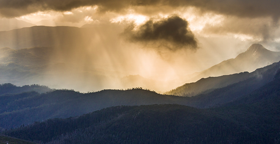 BoM-Tasmania-weather Beautiful light beams through cloudy sky over Tasmanian mountain range (BoM)