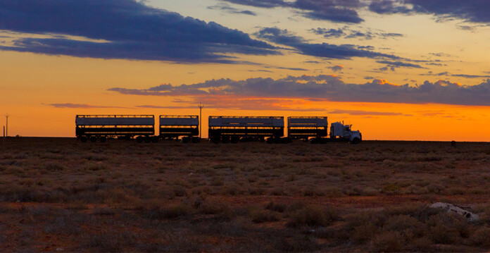 Truck carrying road train through Australian Outback at sunset (radioactive)