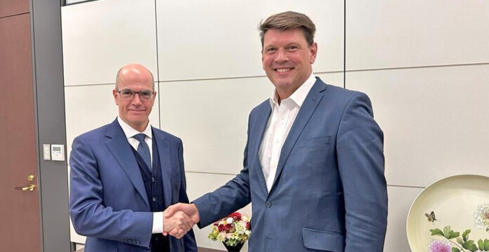 Hitachi Energy CEO Claudio Facchin shaking hands with Transgrid CEO Brett Redman in Hitachi's offices in Tokyo