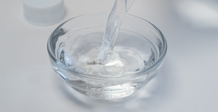 White vinegar being poured into a small clear glass bowl