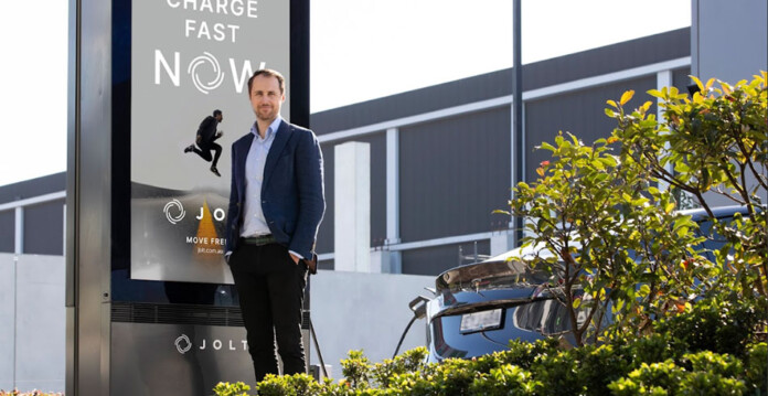 JOLT CEO Doug McNamee in suit in front of JOLT HQ