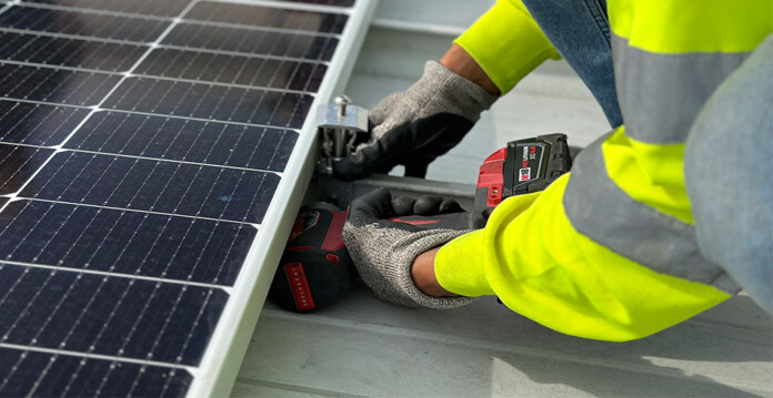 Close up of solar installer working on solar roof panels (S-5-University)