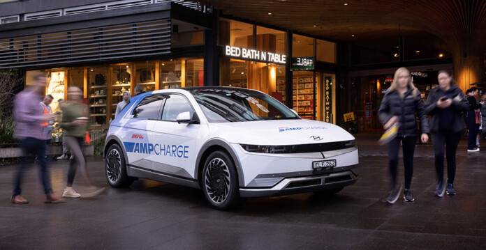 Ampcharge Ampcharge-branded electric vehicle in a Mirvac retail shopping precinct with people walking past