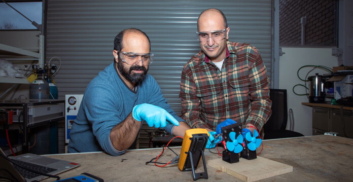 Two male researchers in a lab testing their new proton battery prototype