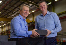 MGA Thermal secures $17M for commercial tech rollout Two men in blue shirts hold thermal energy storage block (MGA Thermal)