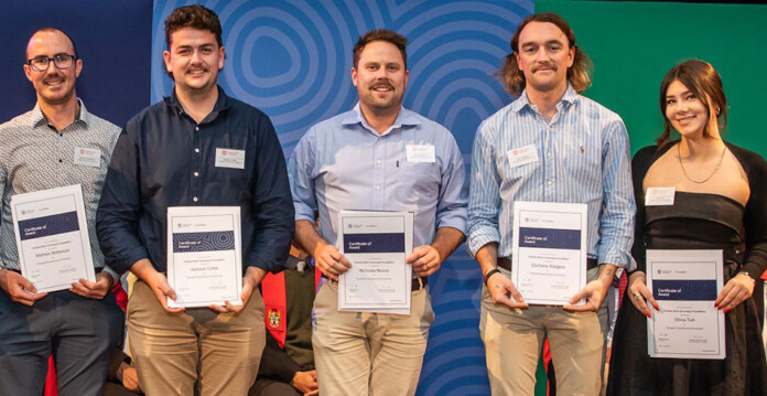 SCU students stand smiling with their scholarships (transgrid)