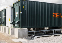 Zenobē raises $400M to drive zero-emission transport Large grid-scale batteries with Zenobe branding in front of high-voltage transmission tower
