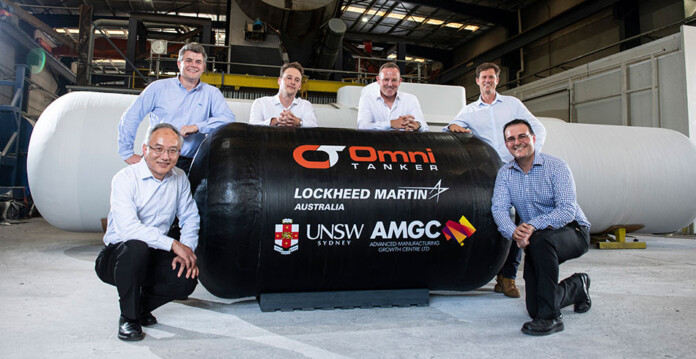 Research and manufacturing team members pose with liquid hydrogen storage tanks