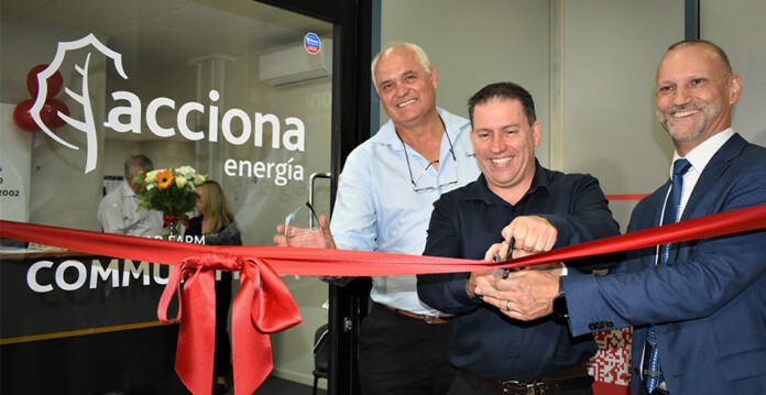 Three smiling men cut ribbon at opening of ACCIONA community hub in Gladstone (Aldoga)