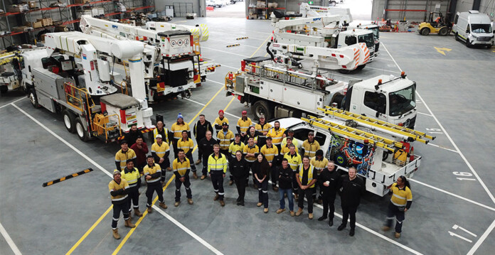 Zinfra staff wearing safety gear gather around work vehicles in new Pakenham depot