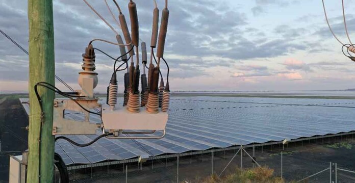 Close-up of NOJA's OSM Recloser with solar farm in background