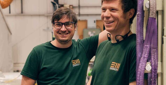Two smiling men wearing green Exergy3 t-shirts