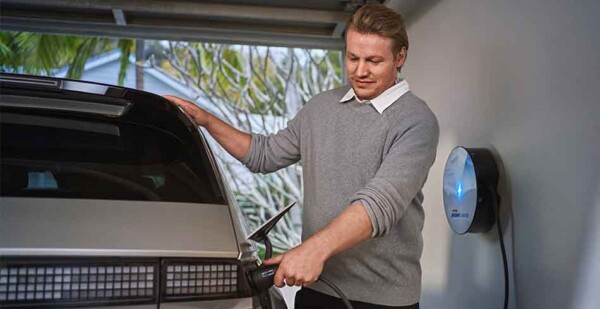 Middle-aged male charges electric car with home EV charger