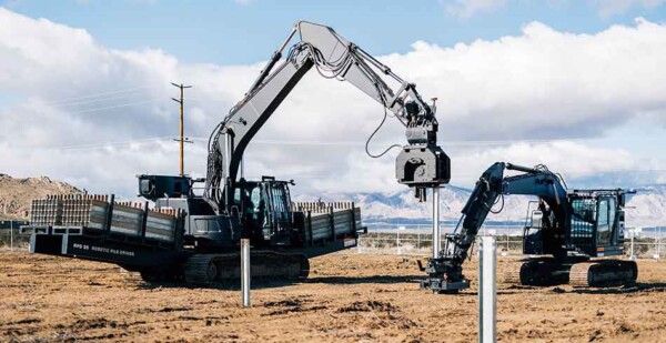 Two construction robots working on a solar farm site