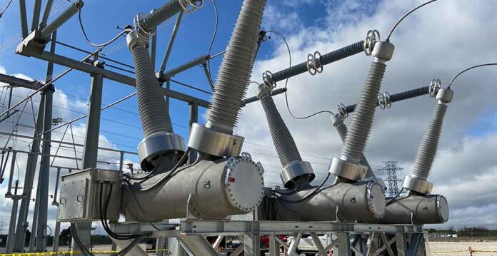 gevernova-powerlink Transmission equipment in switchyard with blue sky and white clouds overhead