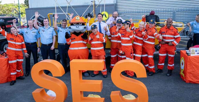 SES-powerlink State Emergency Service volunteers in high-vis jumpsuits standing in front of bright orange SES sign