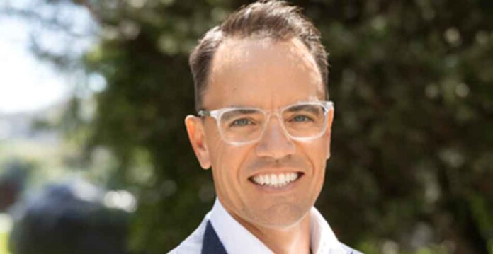 willemsen-bell Headshot of smiling male executive in suit with clear-framed glasses