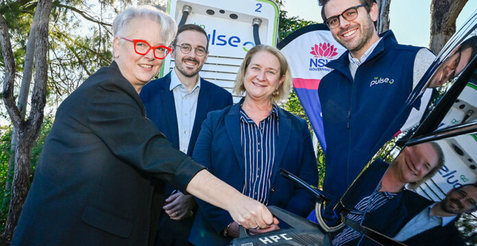 NSW-EV-launch Officials gather around electric car and EV fast charger while posing for photo