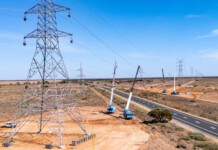 AER rejects Transgrid’s bid to recoup cost blowout Crane trucks working on transmission towers in regional Riverina town