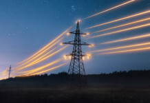 $30 million in grants to strengthen Australia’s grid Transmission towers with illuminated power lines against evening sky