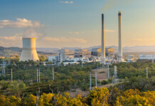Queensland Parliament passes Crisafulli’s new energy laws Coal-fired power station with chimneys and a smoke stack, and blue cloudy sky overhead