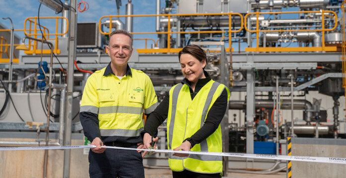 carbon280 Man and woman wearing high-vis clothing cut ribbon in front of hydrogen pilot demonstration plant