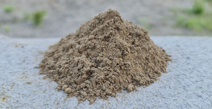 coal-fly-ash Pile of brownish-grey coal fly ash on flat surface