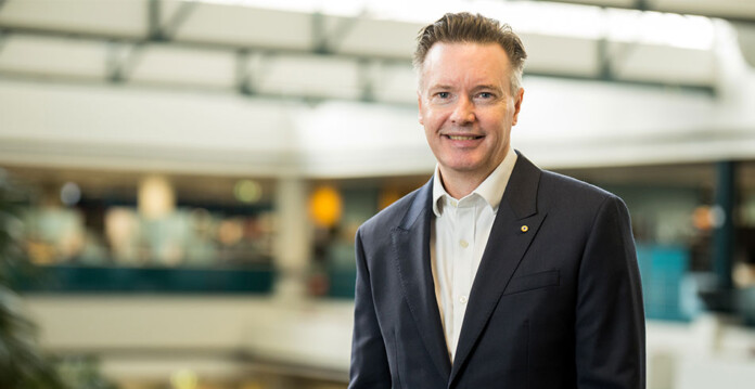 paul-simshauser Smiling male executive wearing dark business suit