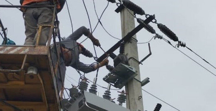 Energy worker installing equipment on power liine