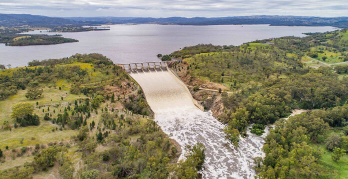 Aerial shot of water pouring from a large dam