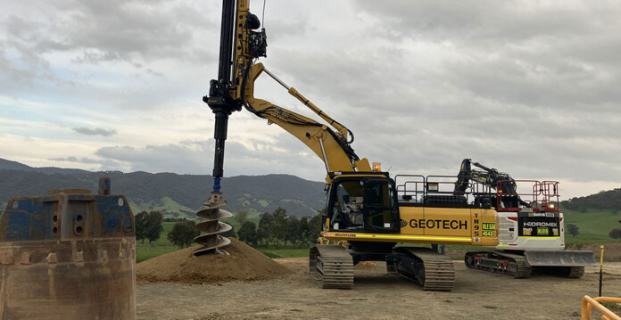 Huge pile driver drills hole on construction site