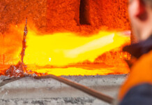 A transition to what, when, how, and at what cost? Smelter worker uses tool to prod molten aluminium in furnace