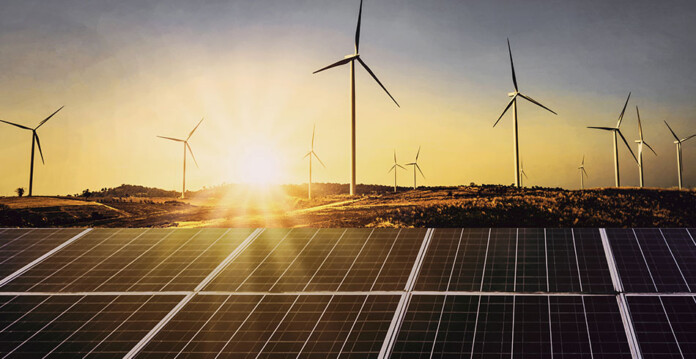 wind farm with solar panels in foreground and beautiful sunset in background