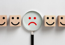 Victoria’s most complained about energy retailer cops fine Image depicting frowning face with magnifying glass over it, among four smiling faces