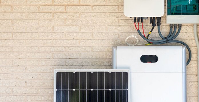 Home battery system with solar panel against cream coloured brick wall
