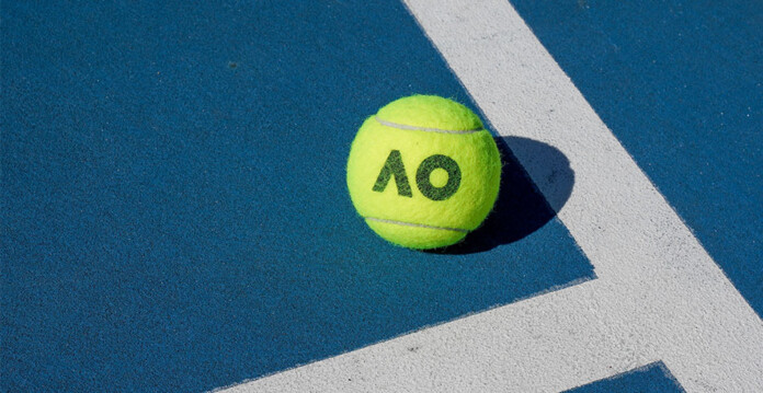 Tennis ball with Australian Open logo sits next to white lines on blue tennis court