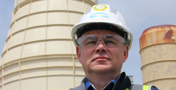 Close up of man wearing a hard hat with ENGIE logo and safety glasses