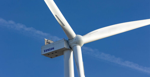 Close up of wind turbine with Vestas logo with blue sky in background