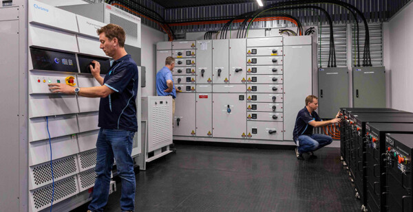 Engineers in room with computer equipment and power supplies