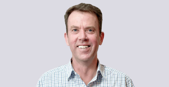 Head and shoulders shot of smiling member of parliament Dan Tehan wearing checked business shirt