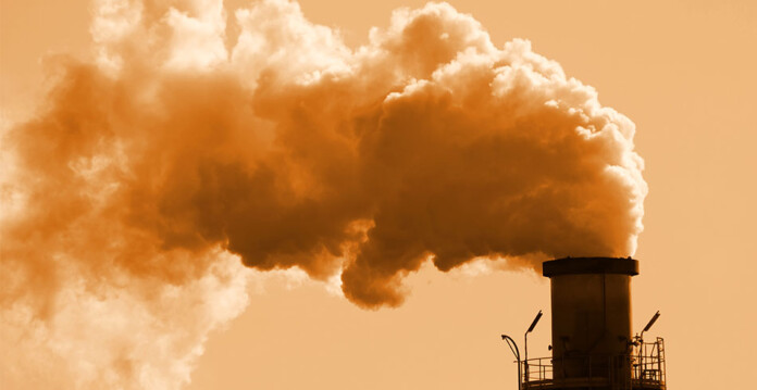 Smoke pouring from chimney at a fossil fuel plant