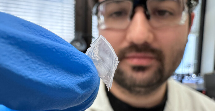 nylon-film Researcher in lab coat holds up nylon film prototype with gloved hand