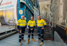 Snowy 2.0 project welcomes new TBM Monica Three men in high-vis workwear stand in front of massive tunnel boring machine