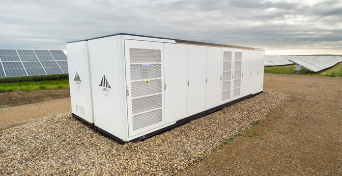 White battery energy storage system with solar farm in background