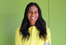 Zinfra achieves record female and First Nations staff intake Dark-haired woman in yellow shirt poses for photo against bright green wall