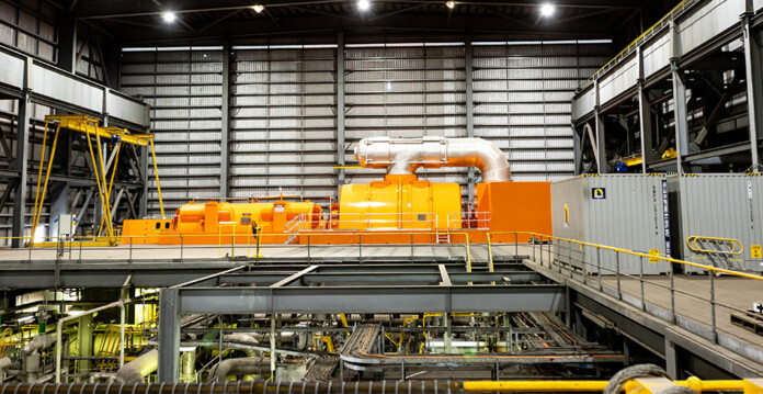 Large orange coal-fired turbine in massive turbine hall