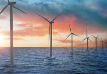 Australian offshore wind sector update Offshore wind turbines in a line with beautiful orange sunset in the background